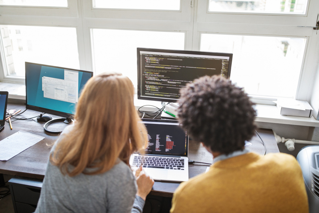 Deux personnes en travail d’équipe devant un ordinateur